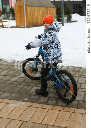 Boy riding a bike during winter holidays 112475546