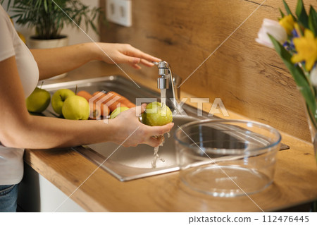 Middle select of woman wash apples. Preparing fruits for healthy homemade juice 112476445