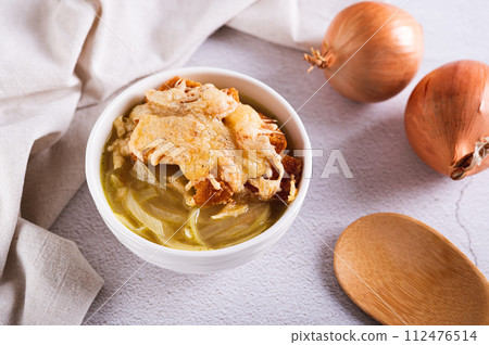 French onion soup with baked cheese bread in a bowl on the table 112476514