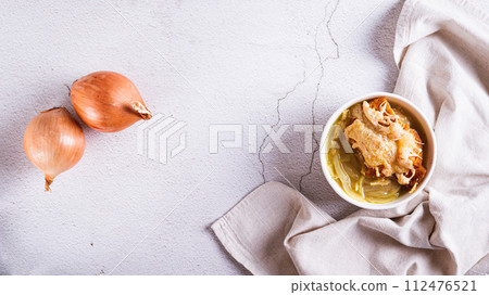French onion soup with baked cheese bread in a bowl on the table top view web banner 112476521