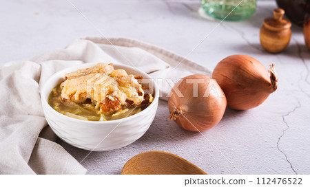 Homemade onion soup with croutons and cheese in a bowl on the table web banner 112476522