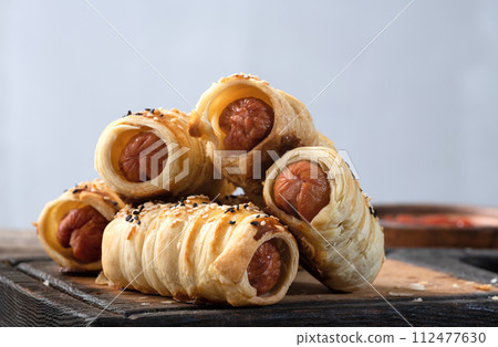 Homemade Sausage in dough rolls on plate Homemade Sausage in dough rolls on plate 112477630