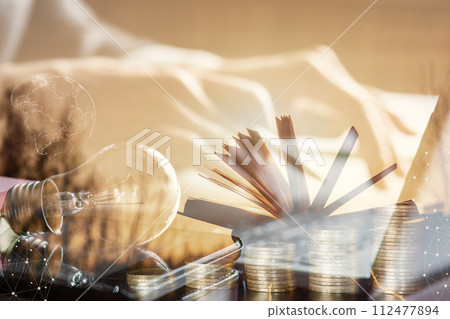 Against a sunny double exposure of office computer and textbook. 112477894