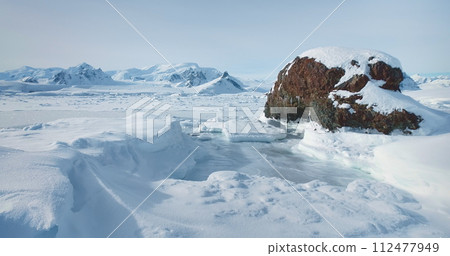 Antarctic snow mountain range winter landscape. Fly over the untouched wilderness of Antarctica. Breathtaking journey to frozen Arctic snowy land. Travel, explore icy wonders. Low angle drone flight Antarctic snow mountain range winter landscape. Fly over the untouched wilderness of Antarctica. Breathtaking journey to frozen Arctic snowy land. Travel, explore icy wonders. Low angle drone flight 112477949