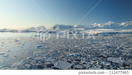 Arctic landscape in sunny day, snow covered mountains and ice water ocean. Antarctica winter landscape, global warming problem. Desert white land of snow and ice. Aerial drone flight over wild nature Arctic landscape in sunny day, snow covered mountains and ice water ocean. Antarctica winter landscape, global warming problem. Desert white land of snow and ice. Aerial drone flight over wild nature 112477965