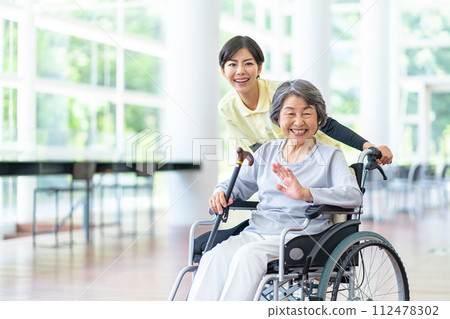 Caregiver and old woman, senior woman sitting in a wheelchair Caregiver and old woman, senior woman sitting in a wheelchair 112478302