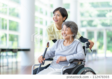 Caregiver and old woman, senior woman sitting in a wheelchair Caregiver and old woman, senior woman sitting in a wheelchair 112478303