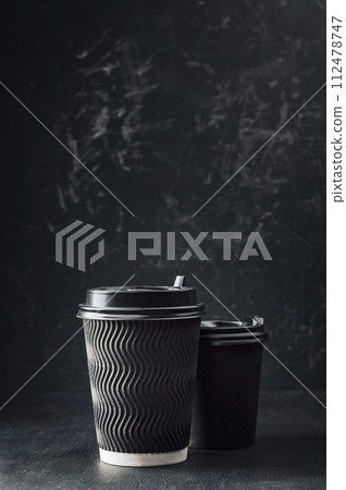 Hot takeaway espresso morning coffee in cardboard paper cup. Coffee to go ,fragrant drink on black. 112478747