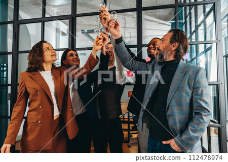 Teamwork and brainstorming concept with businessmen that share an idea with a lamp Teamwork and brainstorming concept with businessmen that share an idea with a lamp 112478974