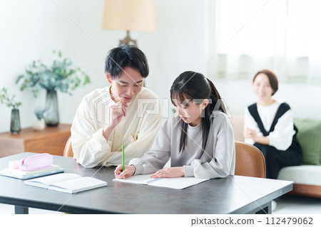 Mother watching over girl studying Mother watching over girl studying 112479062