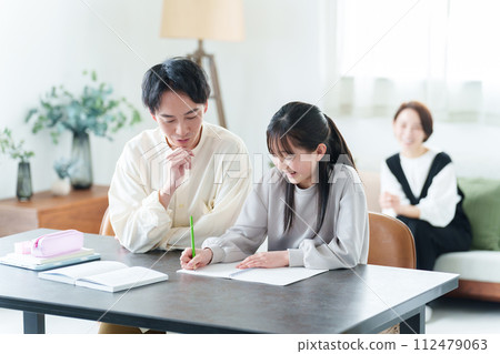 Mother watching over girl studying 112479063