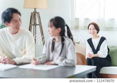 Mother watching over girl studying Mother watching over girl studying 112479070