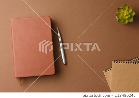 Personal diary with a pen and a potted plant. 112480243