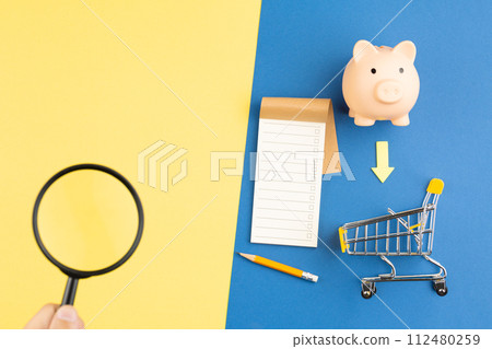 Piggy bank with trolley magnifier and notepad. Piggy bank with trolley magnifier and notepad. 112480259