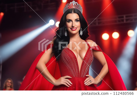 Portrait of a beautiful woman with long black hair posing in a red dress on stage 112480566