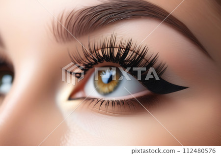 Creative makeup with extended eyelashes and eyeliner arrows. The concept of stylish makeup, close-up Creative makeup with extended eyelashes and eyeliner arrows. The concept of stylish makeup, close-up 112480576