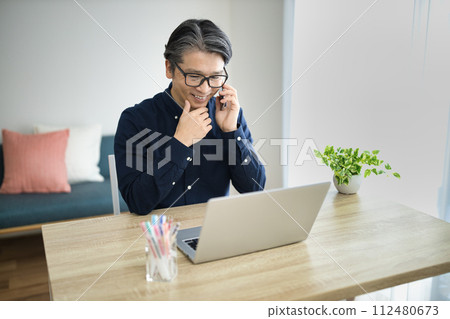 Middle-aged man doing telework in the living room 112480673