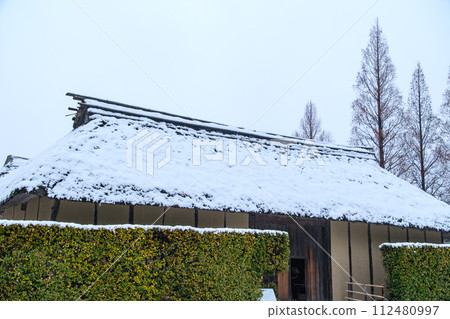 Winter scenery with thatched roof 112480997