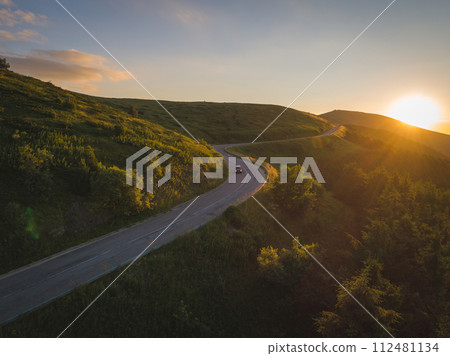 Travelers driving in the mountain road at sunset 112481134