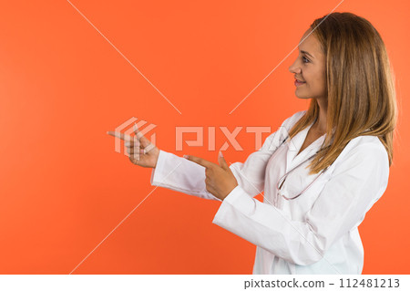 Women doctor smiles and presents a product in front of the camera. 112481213