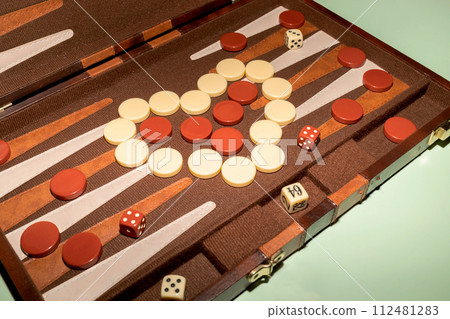 Closeup Backgammon Tables Game. Players Roll Dice, Rectangular Game Board Divided Into Two Halves, Each Featuring 12 Triangular Points Or Pips. Checkers In Shape Of Heart. World Backgammon Day 112481283
