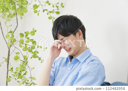 young man crying in the living room 112482058