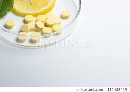 維生素補充劑和檸檬白色背景 維生素補充劑和檸檬白色背景 112482429