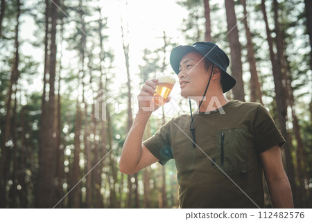 Male camper drinking beer at the campsite (alcohol, alcohol, craft beer, low-malt beer) 112482576