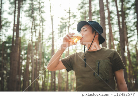 Male camper drinking beer at the campsite (alcohol, alcohol, craft beer, low-malt beer) 112482577