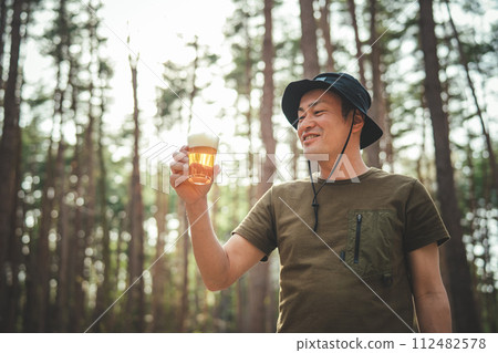 Male camper drinking beer at the campsite (alcohol, alcohol, craft beer, low-malt beer) 112482578