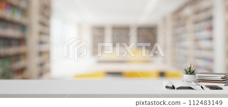 A table features a copy space for display products over a blurred background of a modern library. 112483149