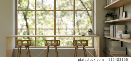 A contemporary neutral lounge features a long wooden table against the window and stools. 112483166