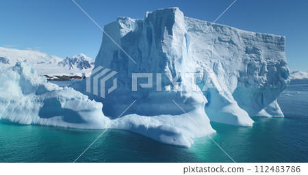Majestic winter Antarctica iceberg drifting ocean in sunny day. Blue sky, turquoise water. Close up snow covered floating glacier panoramic shot. Ecology, melting ice, climate change, global warming Majestic winter Antarctica iceberg drifting ocean in sunny day. Blue sky, turquoise water. Close up snow covered floating glacier panoramic shot. Ecology, melting ice, climate change, global warming 112483786