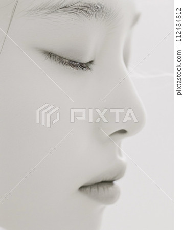 Profile of a fleetingly beautiful Asian woman projected in monochrome 112484812