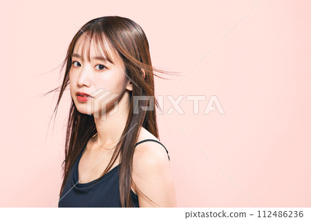 Image of hair care, cosmetics, and skin care of a woman with her hair blowing in the wind 112486236