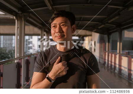 Happy ordinary man walk on the sky-train platform in Bangkok. 112486936