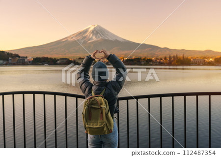 Woman tourist with Fuji Mountain at Lake Kawaguchi, happy Traveler sightseeing Mount Fuji in Fujikawaguchiko, Yamanashi, Japan. Landmark for tourists attraction. Japan Travel, Destination and Vacation 112487354