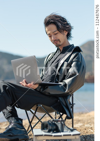 一名30多歲的男子在湖邊遠距工作 112487676