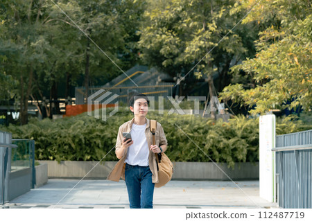 Portrait of handsome Asian student using smartphone Portrait of handsome Asian student using smartphone 112487719