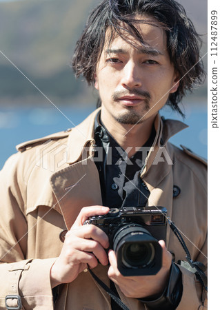 一名30多歲的男子在湖邊拍照 112487899