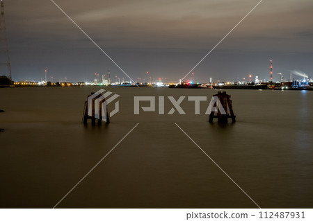 Harbor Nightscape: Industrial Glow Over Calm Waters 112487931