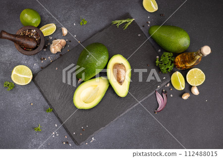 Green Avocado on stone serving board Green Avocado on stone serving board 112488015