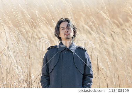 A man in his 30s standing in front of pampas grass 112488109