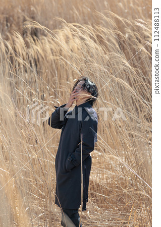 A man in his 30s standing in front of pampas grass 112488113