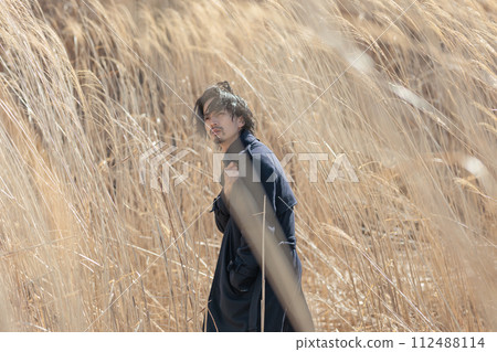 A man in his 30s standing in front of pampas grass 112488114