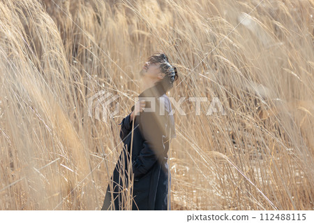 A man in his 30s standing in front of pampas grass 112488115