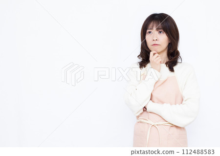 穿著圍裙的家庭主婦認真思考 穿著圍裙的家庭主婦認真思考 112488583