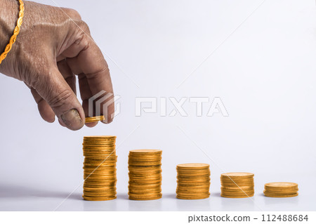 Human hand stacking gold coins on white background. business concept. 112488684