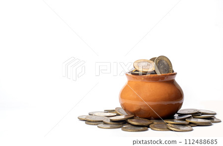 Coins in a clay pot on a white background with copy space. business and finance concept Coins in a clay pot on a white background with copy space. business and finance concept 112488685