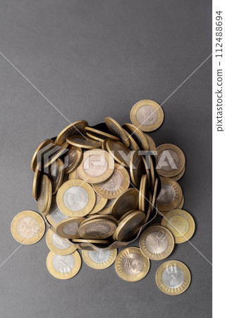 Pile of Indian ten rupee coins on gray background Pile of Indian ten rupee coins on gray background 112488694